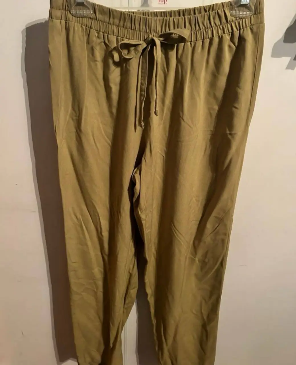 Pantalón suelto de color khaki, con cintura elastizada y cordón para ajustar. Ideal para un look casual y cómodo.