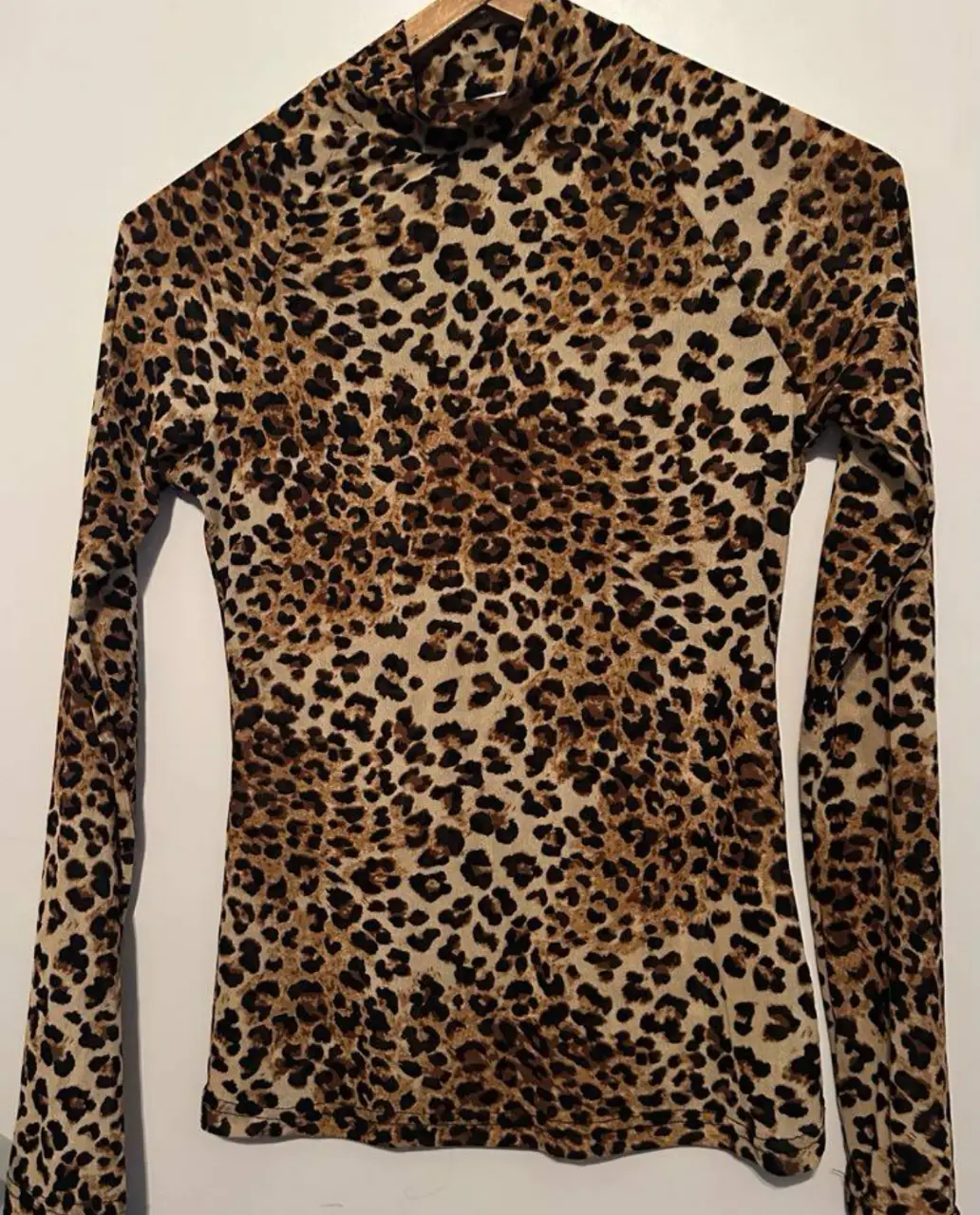 Remera de manga larga con estampado de leopardo. Cuello alto. Ideal para un look audaz y moderno.