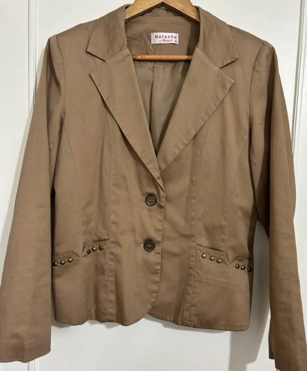 Blazer marrón de mujer, con botones y detalles en los bolsillos. Ideal para un look elegante y versátil.
