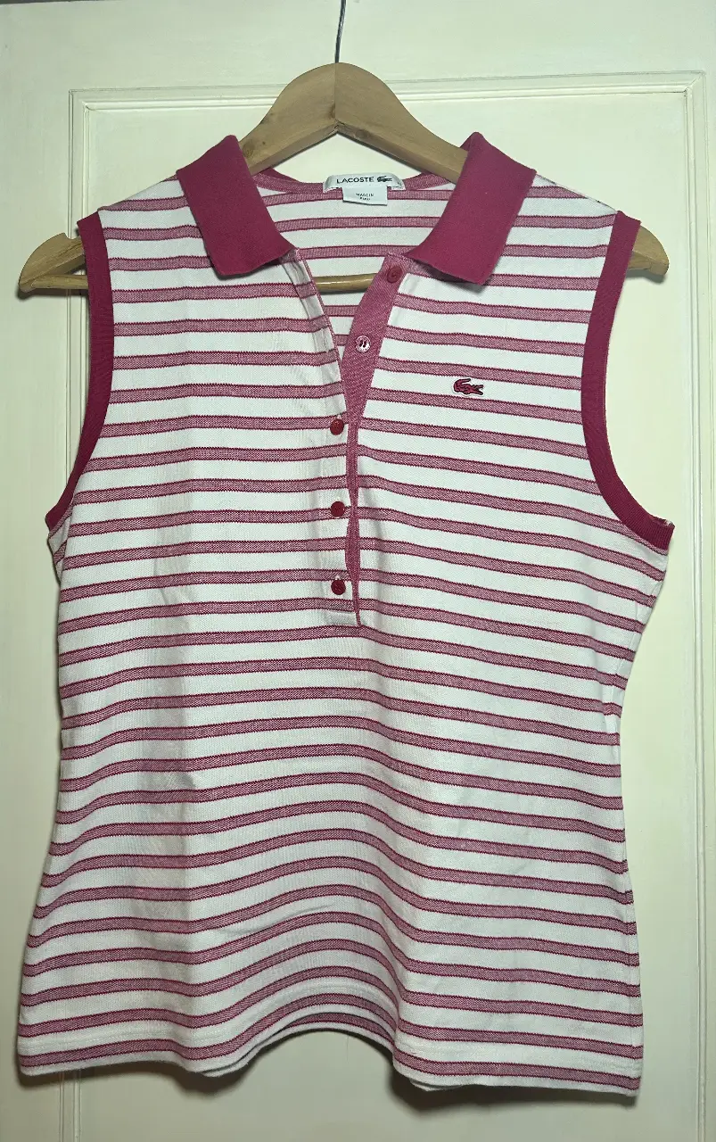 Musculosa Lacoste a rayas rojas y blancas, con cuello y bordes en rojo. Ideal para un look casual y fresco.