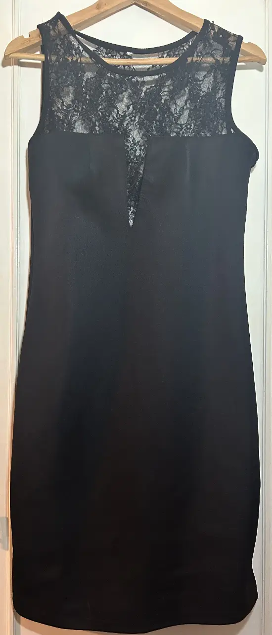 Vestido negro mini con detalles de encaje en la parte superior. Ideal para fiestas y eventos especiales.