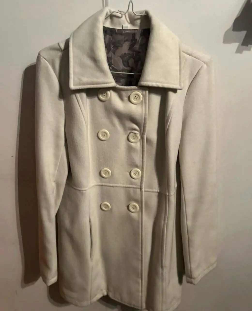 Sobretodo de paño color crudo con botones. Ideal para el invierno.