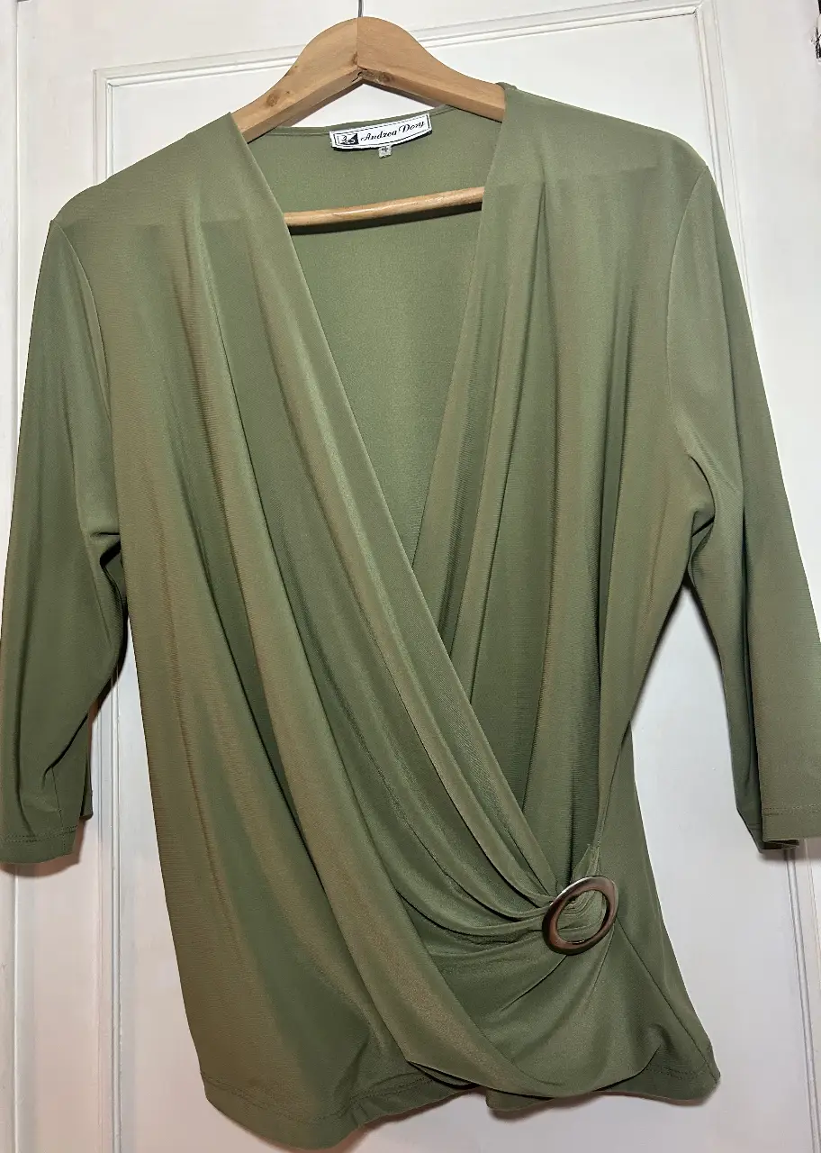 Blusa verde oliva con diseño cruzado y detalle de hebilla. Ideal para un look elegante y sofisticado.