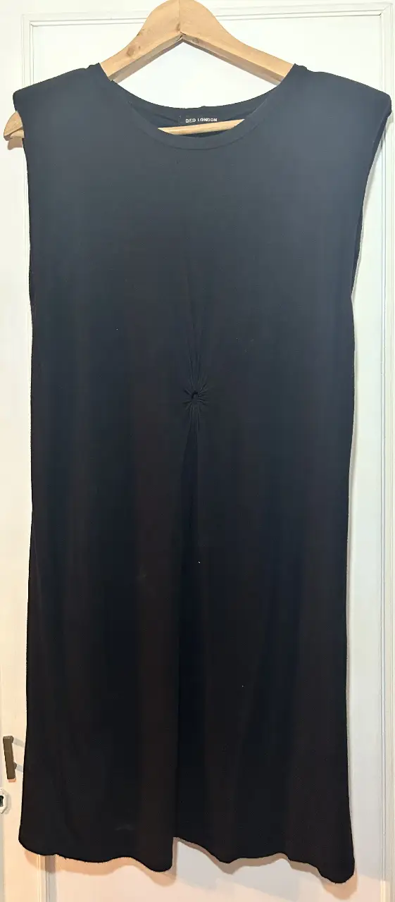 Vestido midi negro, sin mangas, con detalle fruncido en la cintura. Ideal para un look elegante y versátil.