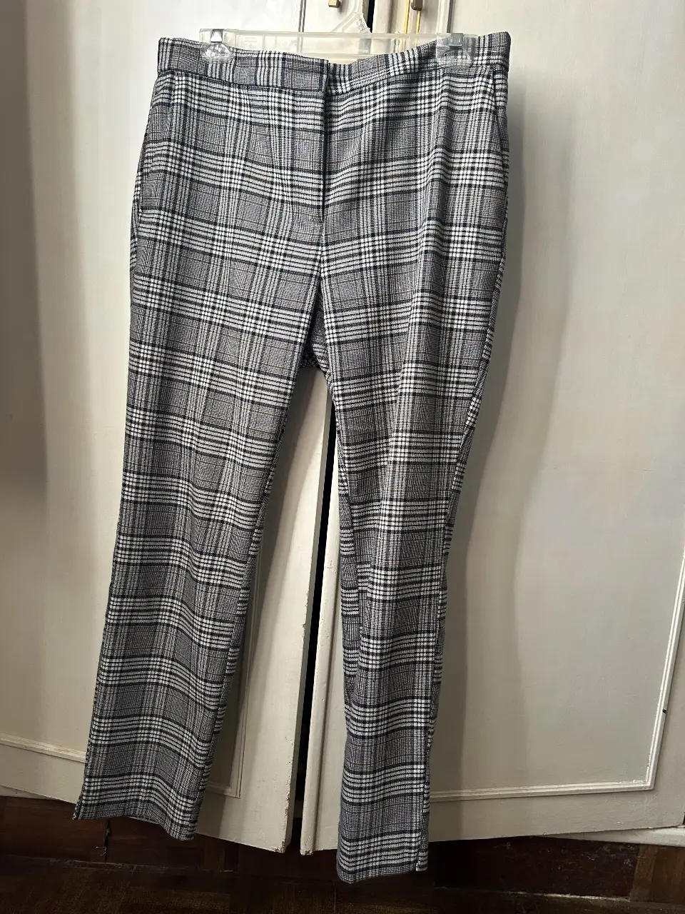 Pantalón sastrero a cuadros en tonos grises y blancos. Corte recto, ideal para un look elegante y versátil.