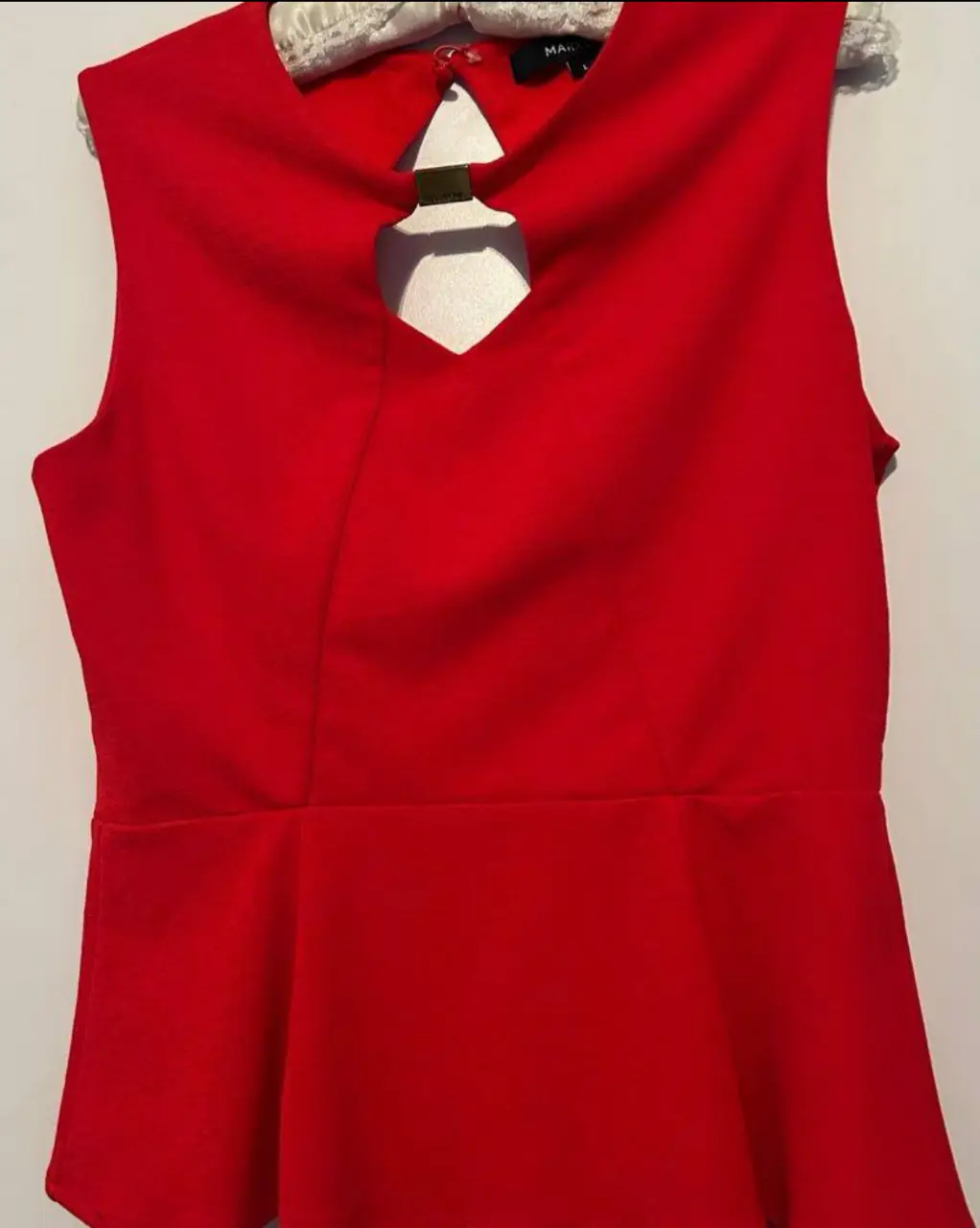 Top rojo sin mangas con detalle de abertura en el cuello. Ideal para un look elegante y moderno.