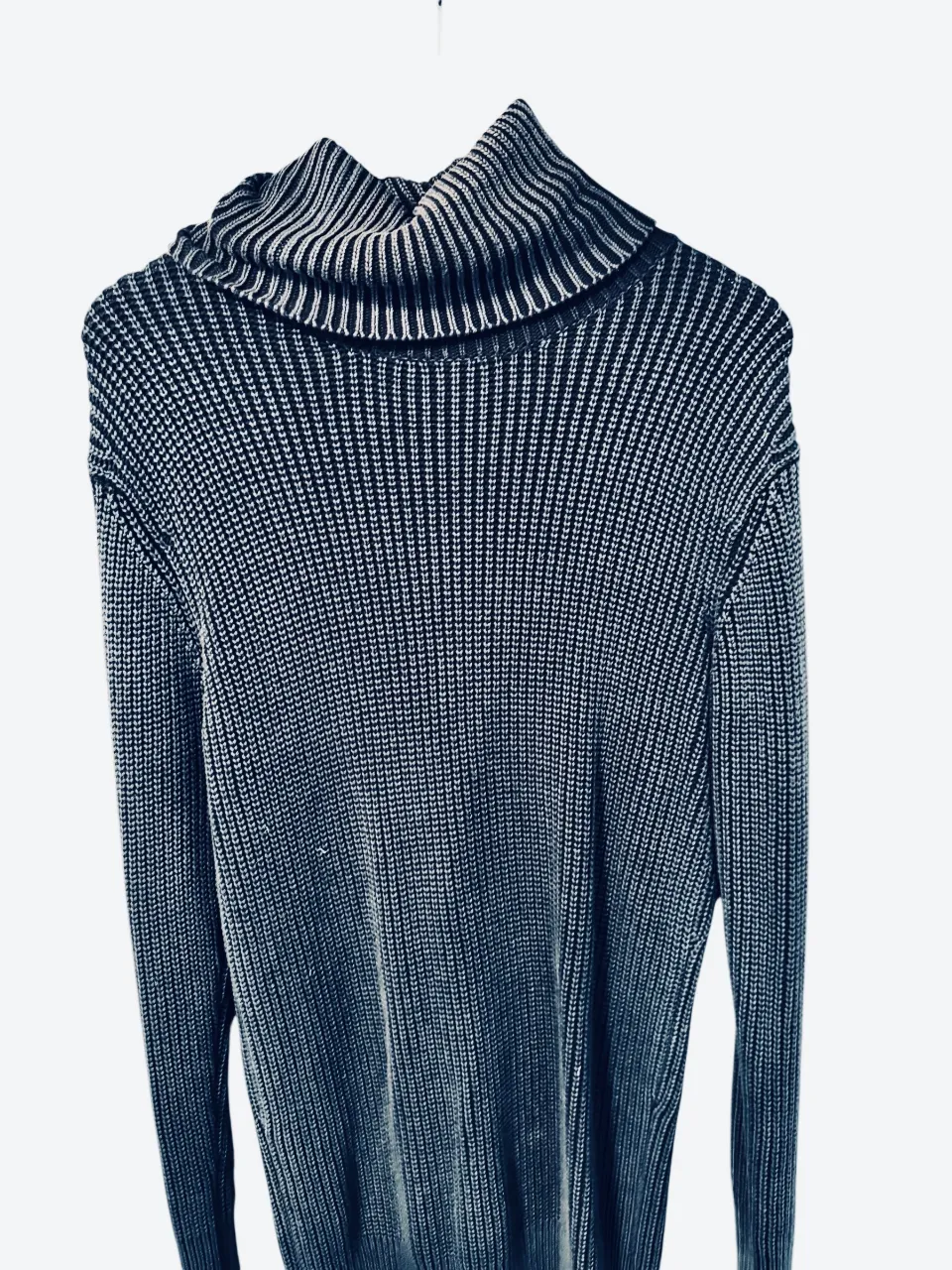 Este es un suéter de punto acanalado con cuello alto (polera/turtle neck) en color Azul/Gris oscuro. Tiene un corte más ajustado al cuerpo, ideal para usar solo o debajo de un saco o campera.
