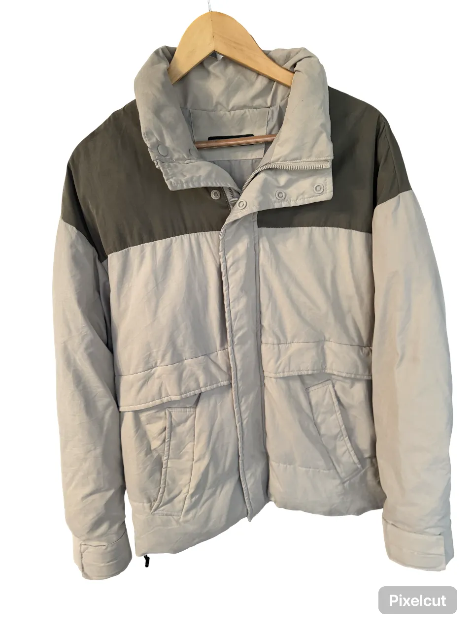 Campera puffer de hombre, con cuello alto y cierre frontal. Diseño bicolor en gris y verde oscuro. Ideal para el invierno.