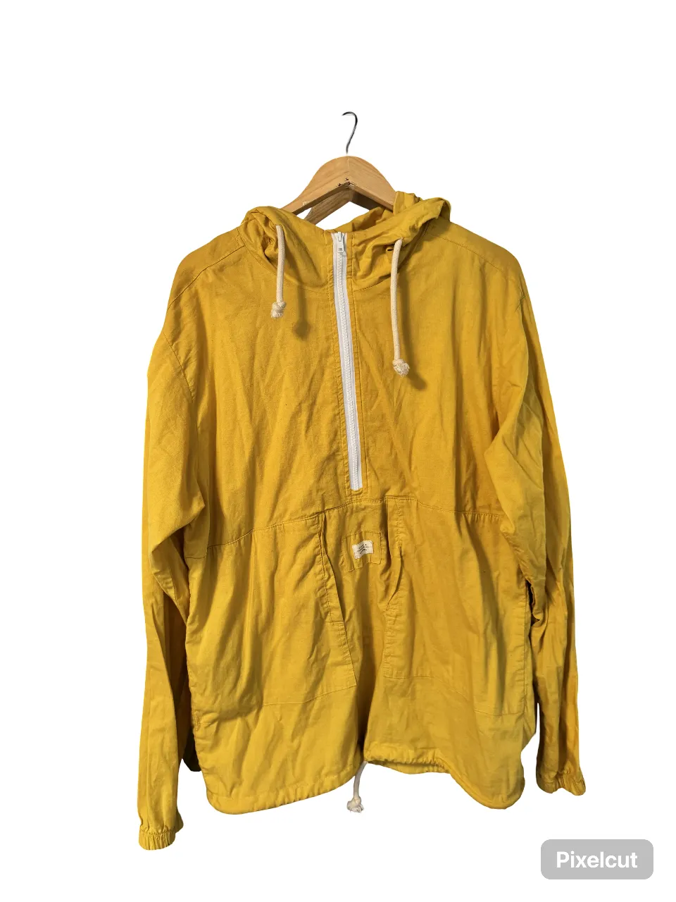 Campera rompevientos amarilla con capucha y cierre . Bolsillo frontal y detalles de cordones blancos. Ideal para un look casual y cómodo.