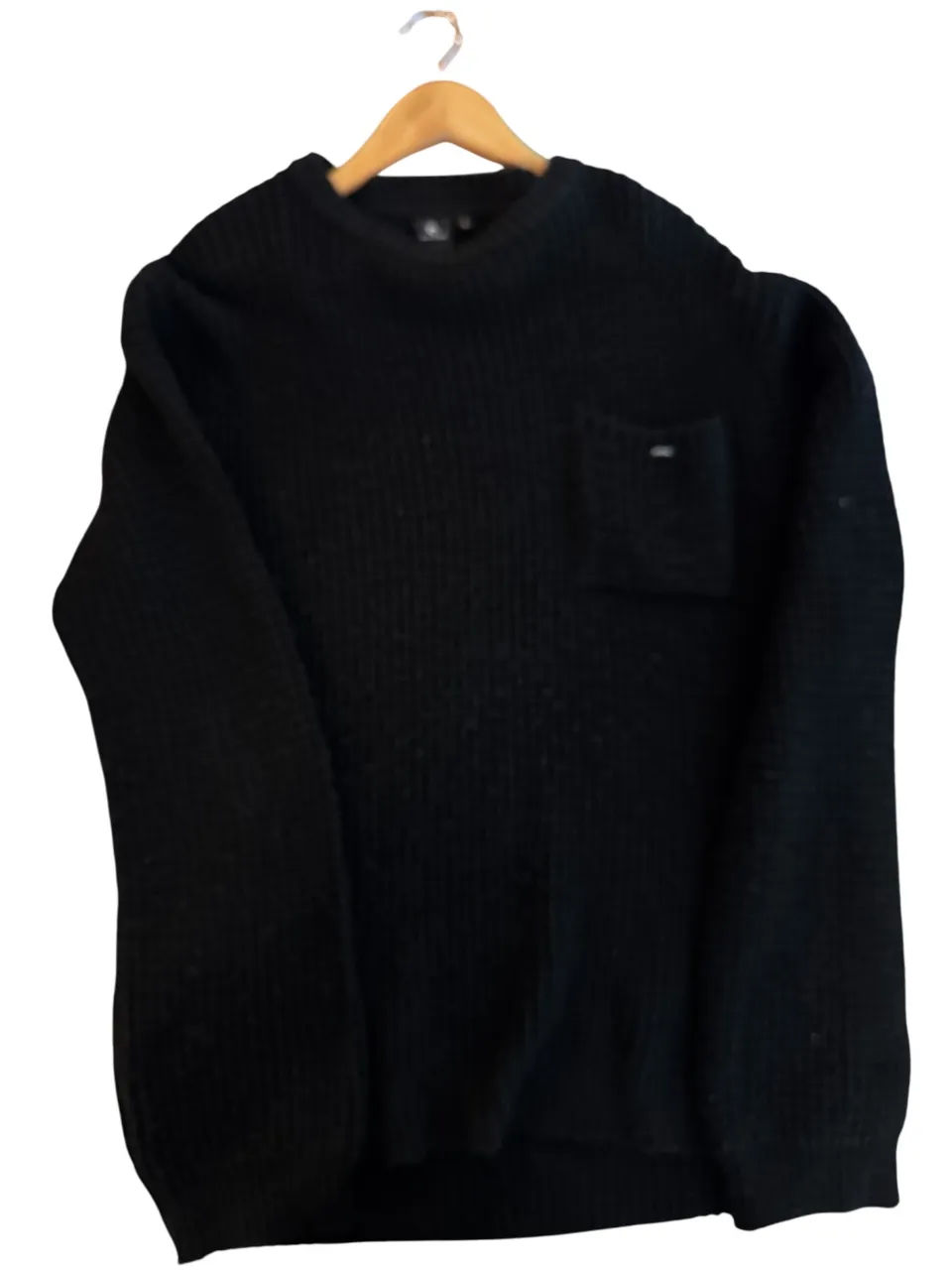 Sweater de hombre negro, de cuello alto, con bolsillo en el pecho y la marca Rip Curl. Ideal para el invierno.