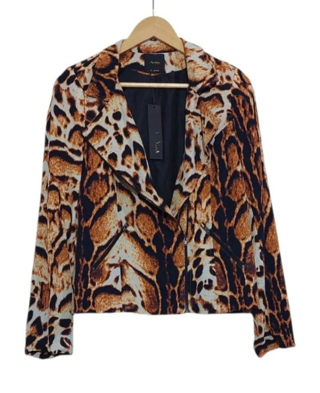 Chaqueta tipo blazer con estampa animal print de leopardo en tonos marrones, negros y crudos. Posee un corte asimétrico con cierre metálico y bolsillos frontales con cierre. Ideal para un look canchero y moderno. viscosa y acetato.
largo 59.  axila 45. hombros 36. mangas 62.