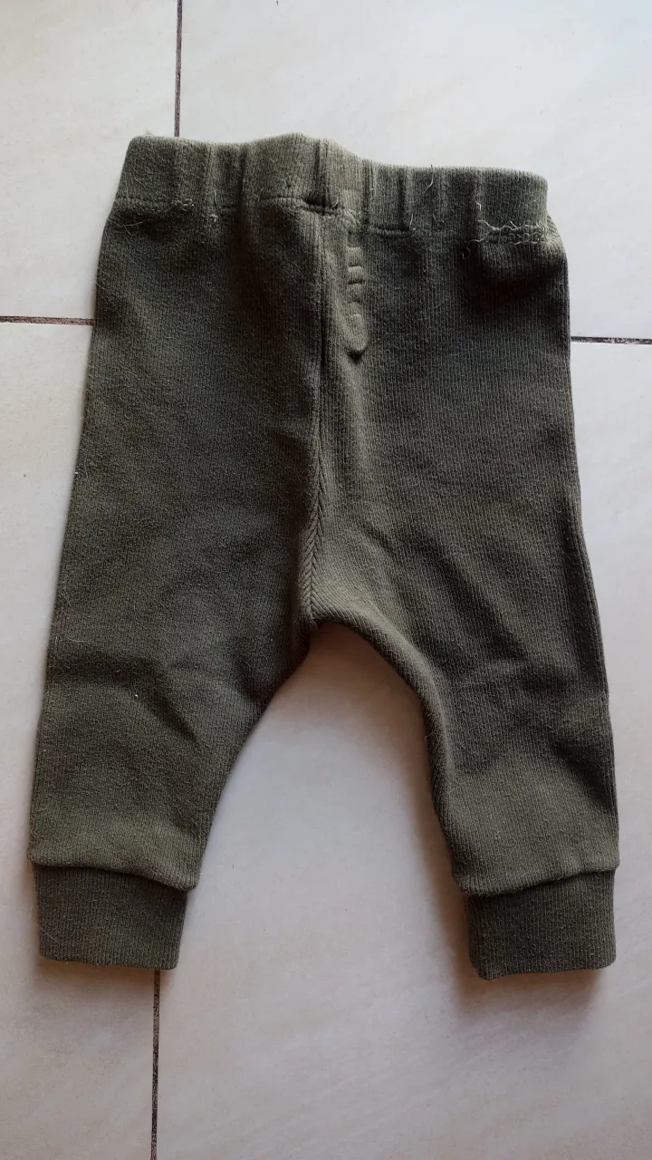 Pantalón de bebé de color verde oscuro, ideal para mantener a tu pequeño cómodo y abrigado. Confeccionado en tejido de punto suave y elástico, este pantalón ofrece un ajuste perfecto y libertad de movimiento. Perfecto para el uso diario. DETALLE: Descocido en la cintura.