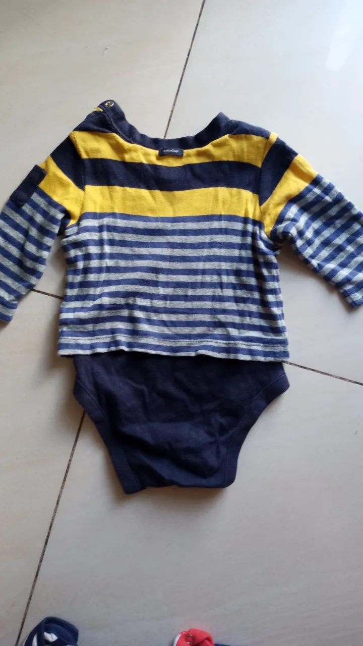 Body de bebé a rayas horizontales en azul y amarillo, con mangas largas. Cuello redondo y botones en el hombro. Ideal para mantener a tu bebé cómodo y abrigado.