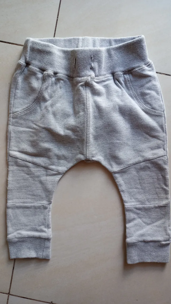 Pantalón de bebé de color gris, ideal para el día a día. Confeccionado en tela suave y cómoda, este pantalón ofrece libertad de movimiento para los más pequeños. Diseño con cintura elástica y puños en los tobillos para un ajuste perfecto. Perfecto para combinar con cualquier prenda.