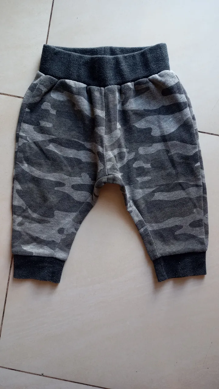 Pantalón babucha para niño con estampado camuflado en tonos grises. Ideal para un look casual y cómodo.