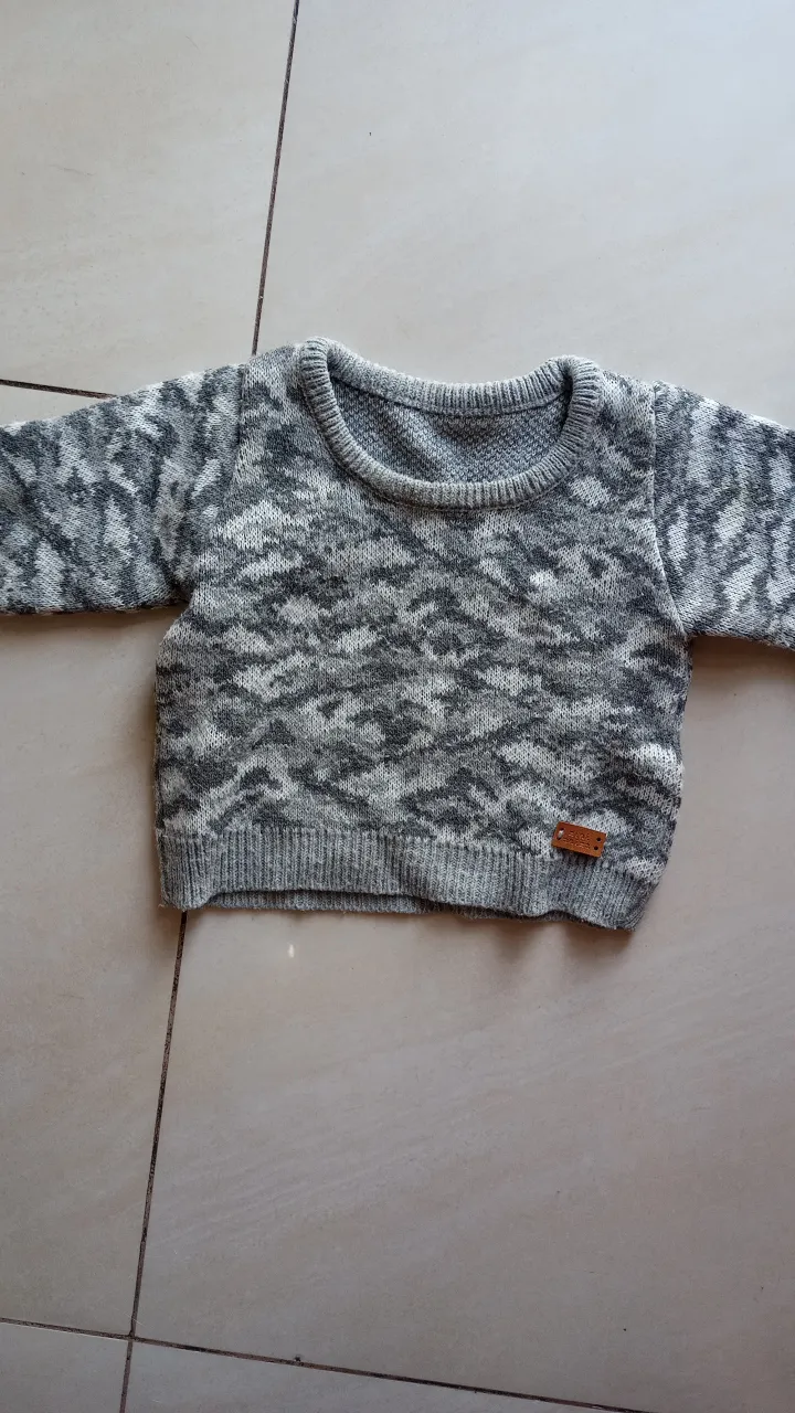 Sweater tejido para niño/a con diseño jaspeado en tonos grises y blancos. Ideal para mantener abrigado a tu pequeño/a con estilo.