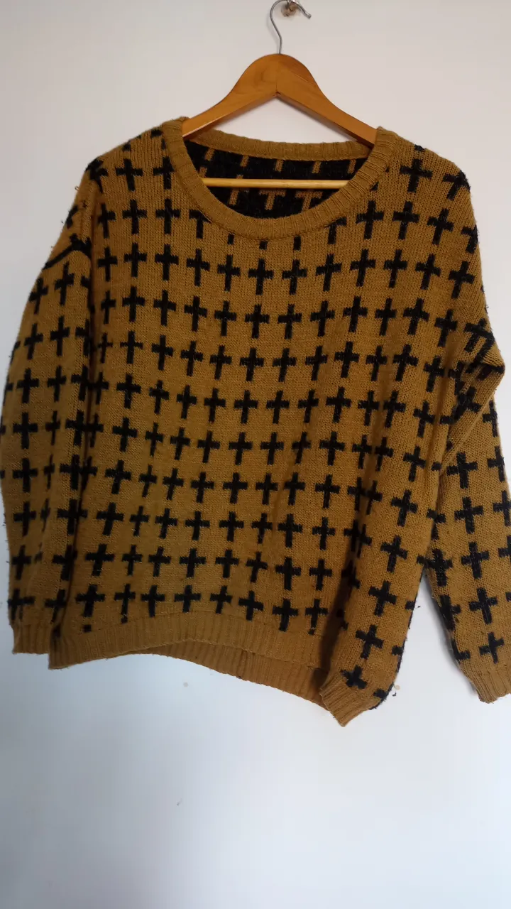Sweater de punto con diseño de cruces en color marrón y negro. Ideal para un look casual y abrigado.