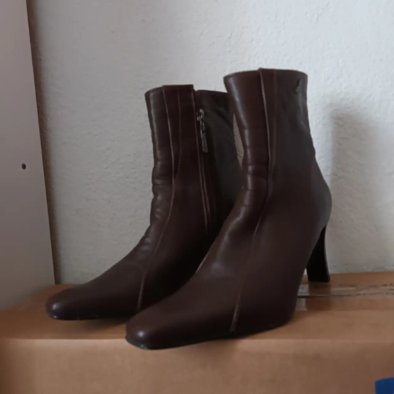 Botas de caña alta de cuero marrón, con taco fino y cierre lateral. Ideales para un look elegante y sofisticado.