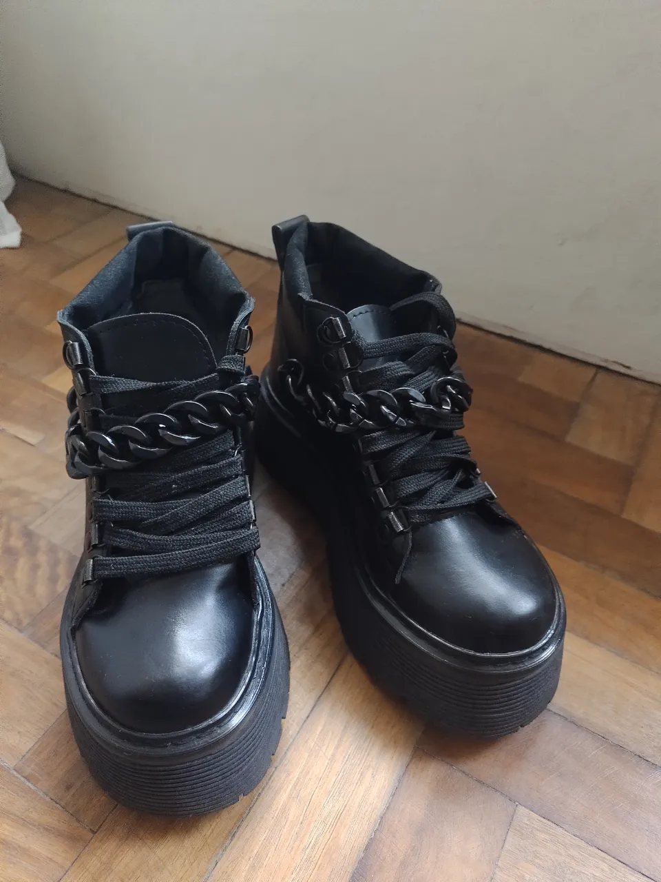 Borcegos negros con plataforma y detalles de cadena. Estilo rocker y urbano, ideales para un look audaz y moderno. Perfectos para combinar con jeans, faldas o vestidos.