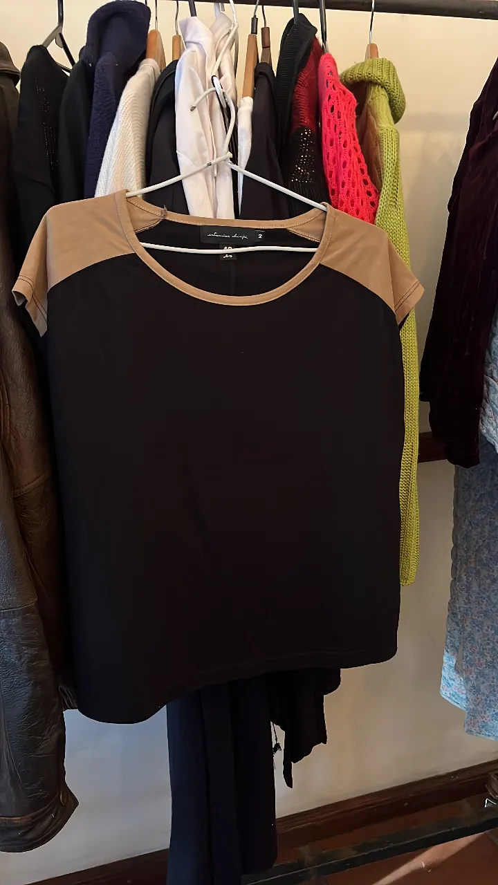 Remera negra con mangas y cuello color beige de gamuza. Ideal para un look casual y cómodo.