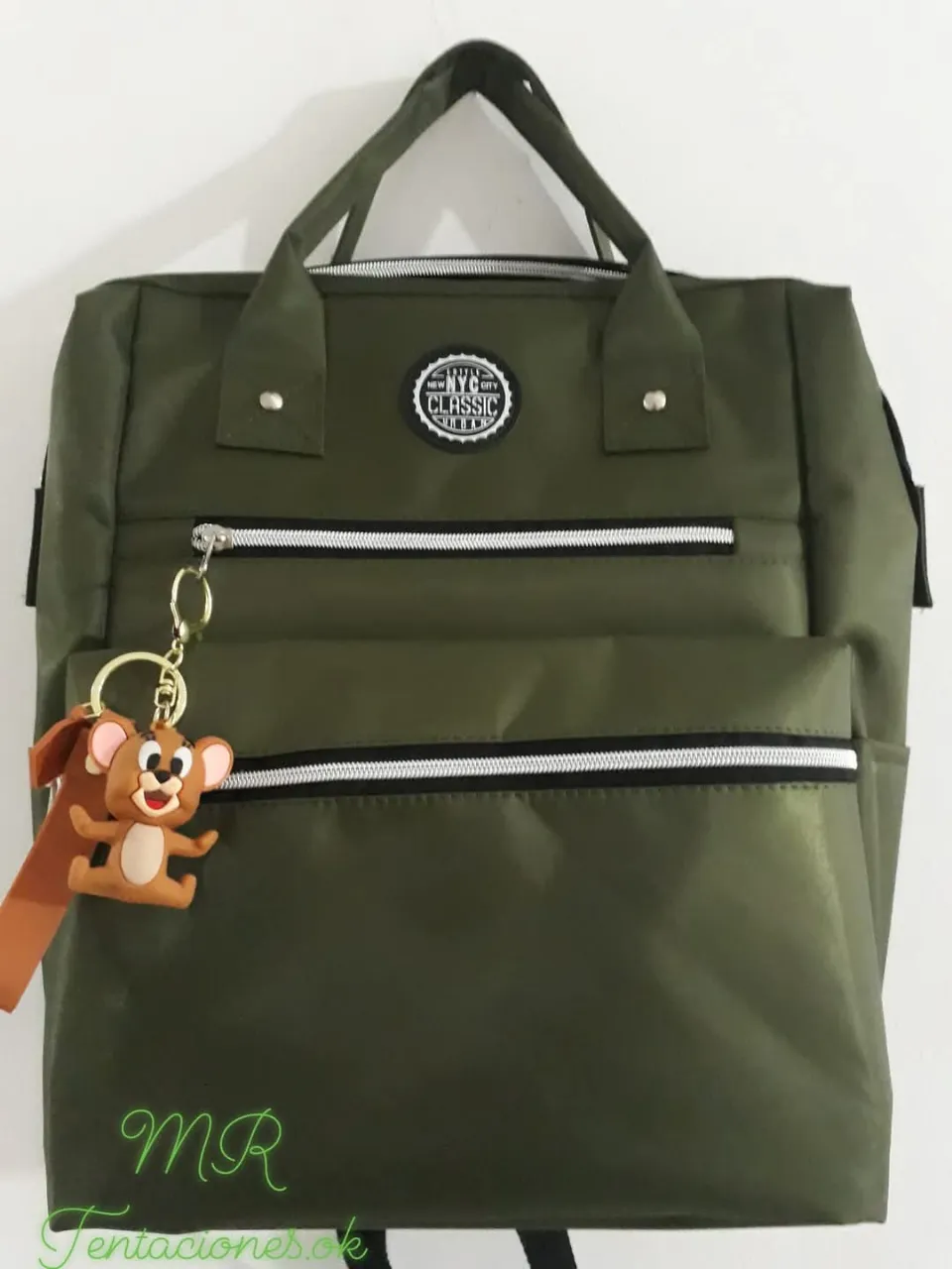 Mochila Impermeable urbana de color verde oscuro con detalles en blanco y negro. Cuenta con un llavero de Jerry. Ideal para llevar tus cosas con estilo.