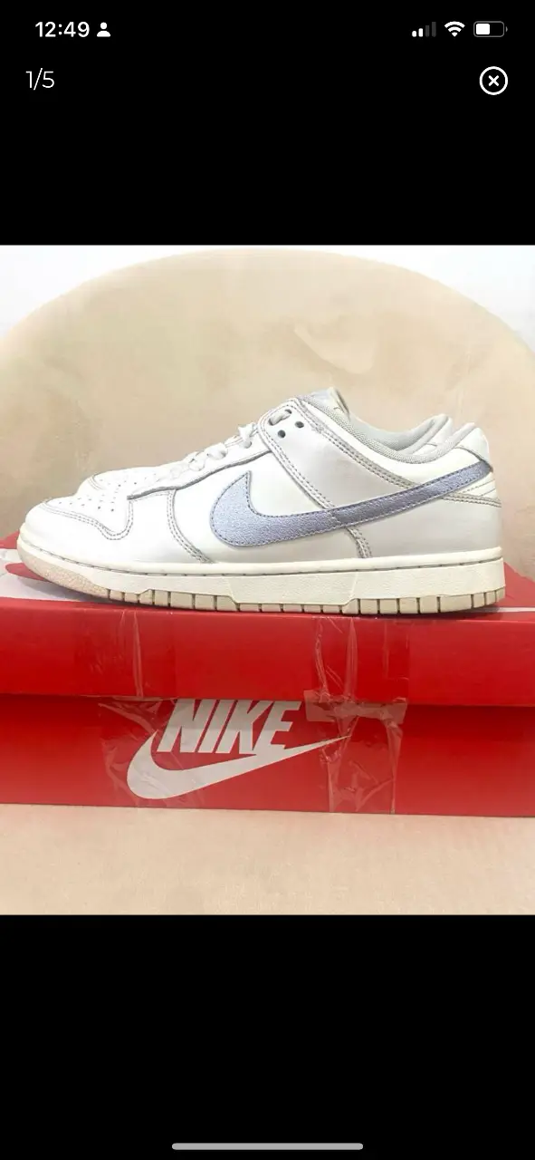 Zapatillas Nike Dunk Low blancas con detalles en gris. Ideales para un look casual y moderno.