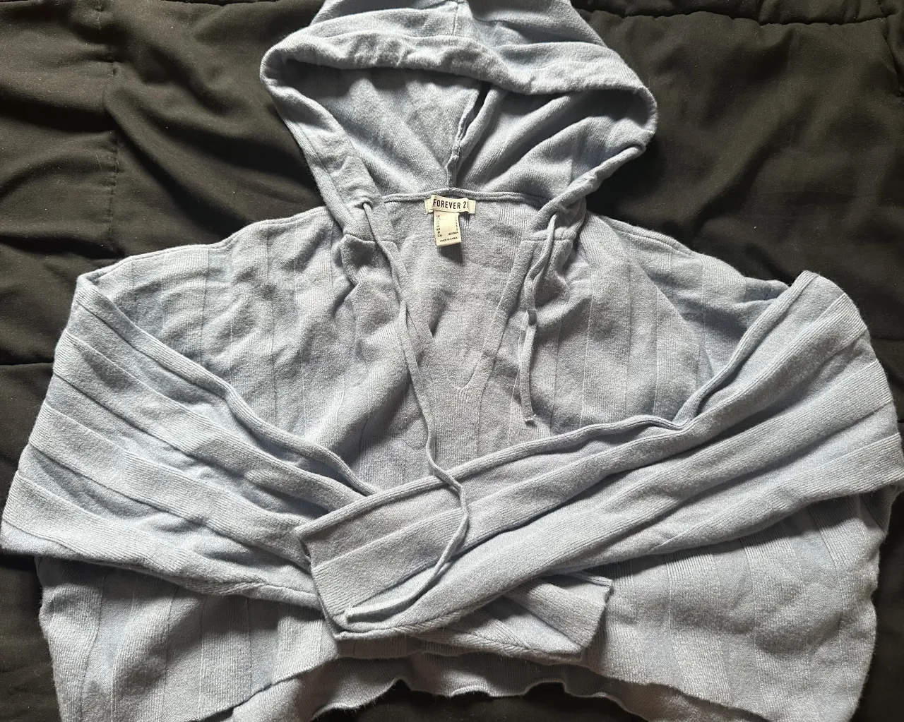 Buzo crop con capucha, de tejido acanalado y mangas largas. Ideal para un look casual y moderno.