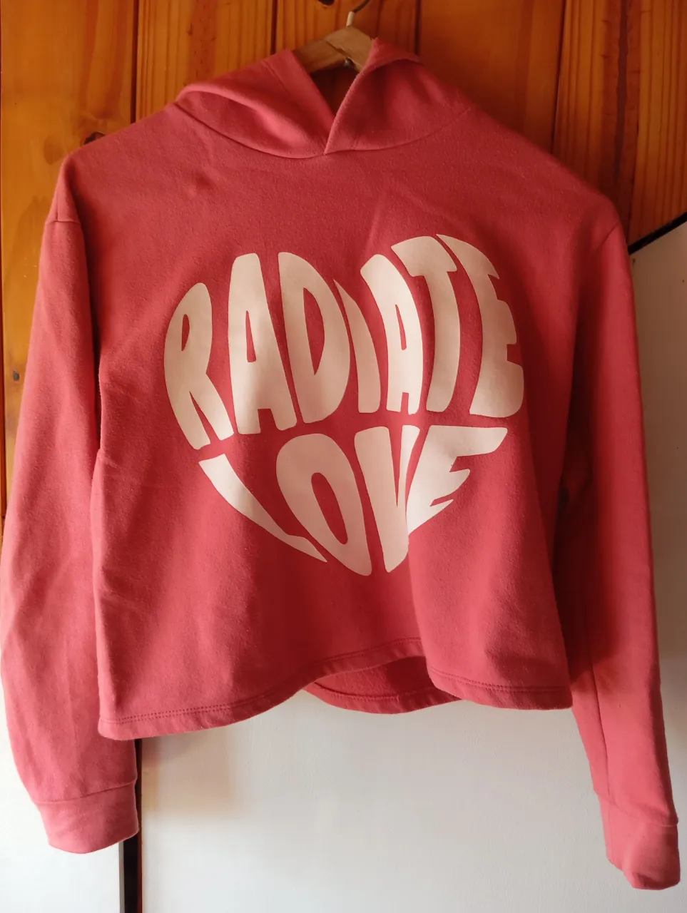 Hermoso buzo crop top con capucha y estampa de corazón "Radiate Love". Ideal para un look casual y canchero.