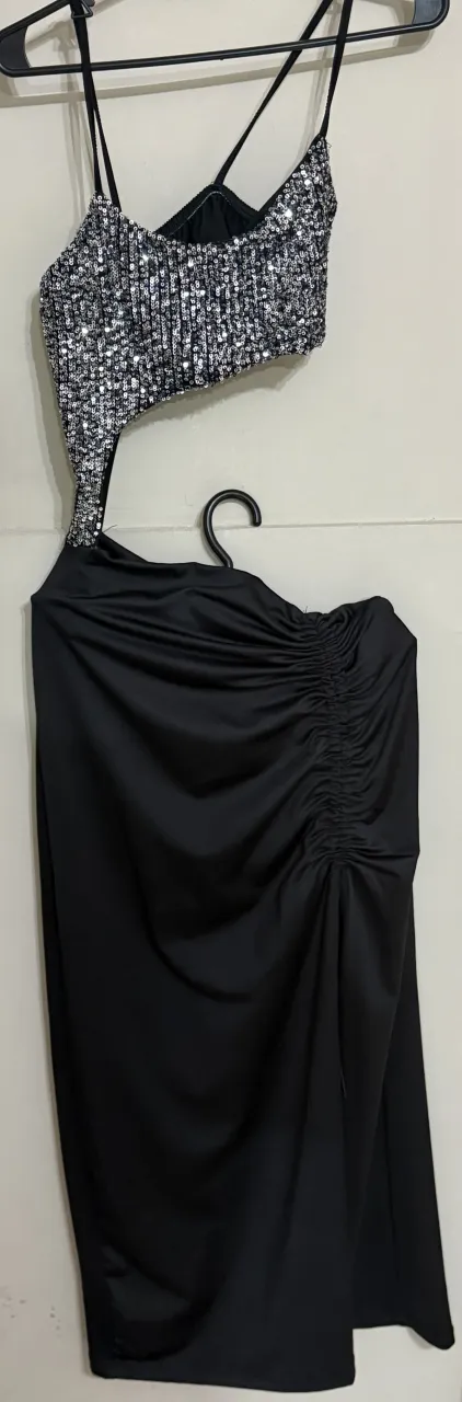 Vestido largo de fiesta, el top tiene lentejuelas plateadas en la parte delantera, la pollera es negra larga y con fruncido lateral regulable. 