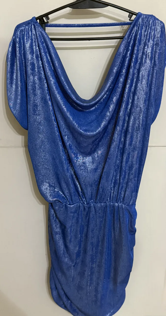 Vestido azul brillante con escote en V y cintura. Espalda descubierta. Modelo mostrando como queda. Es grande el talle. soy un xl y me queda bien
