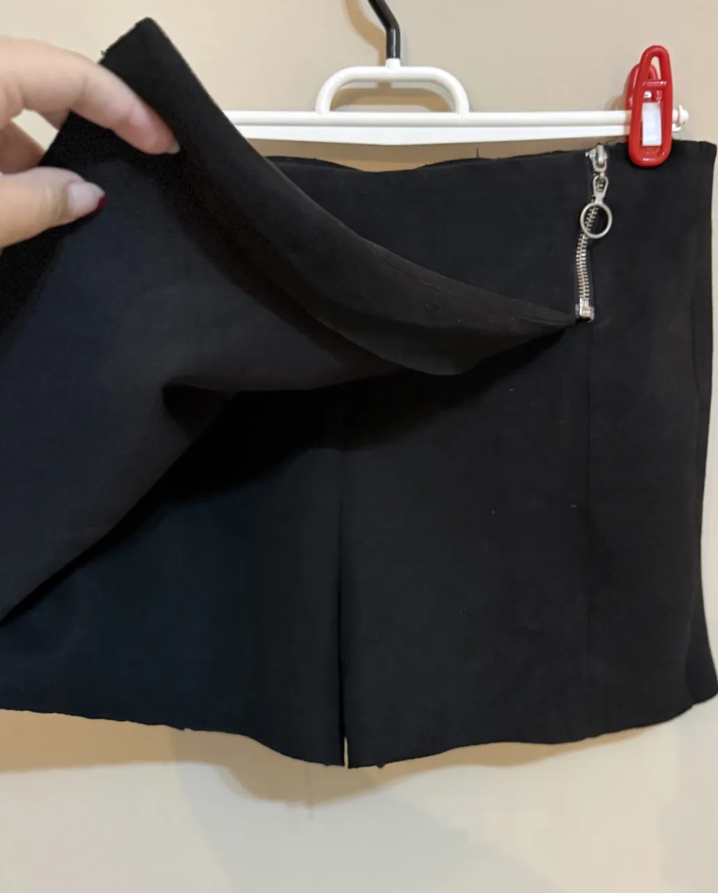 Short pollera negros con detalle de cierre metálico en el lateral. Desgastado en la parte de arriba (costuras)