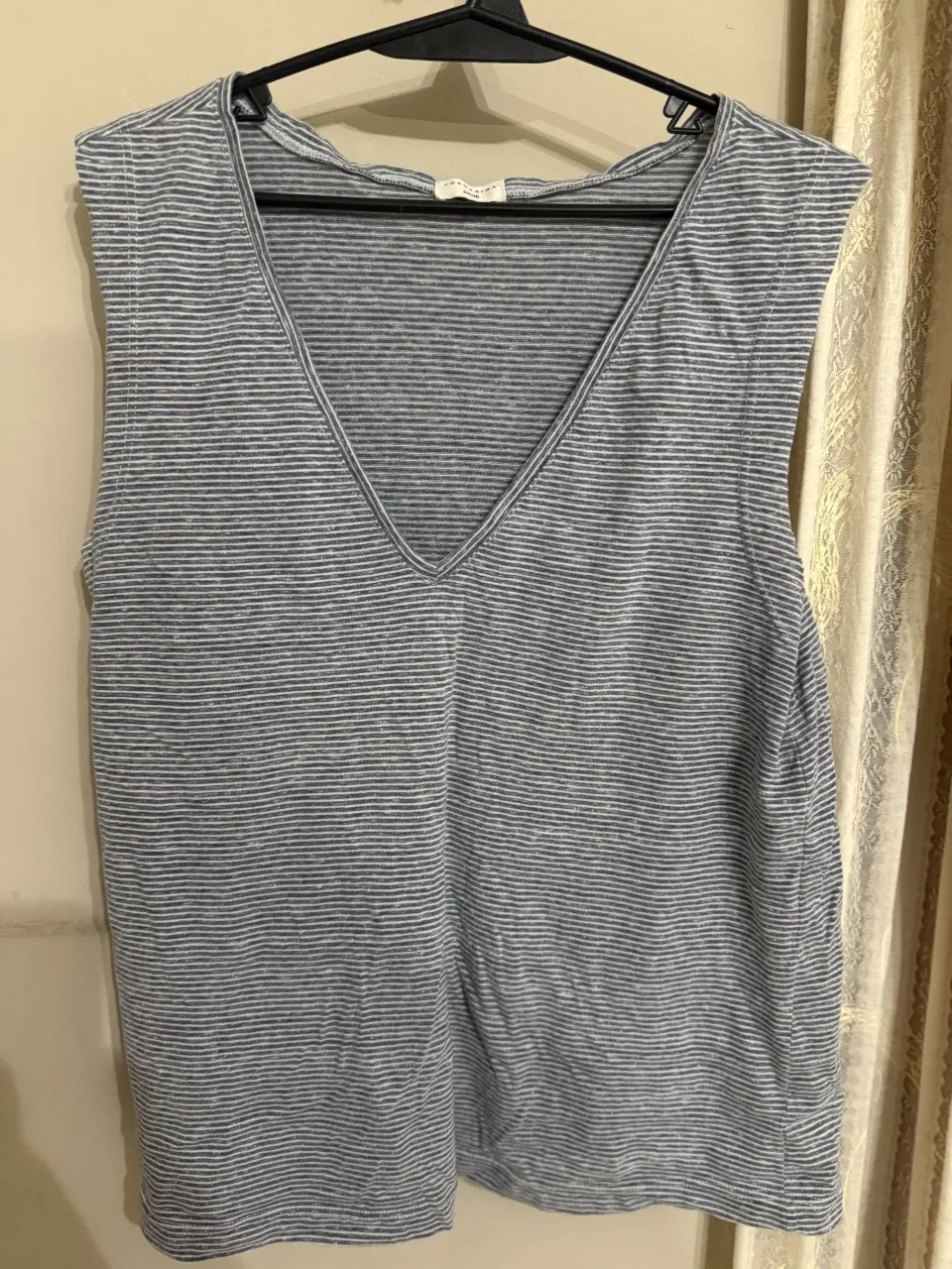 Musculosa a rayas finas grises y blancas. Escote en V. es S pero es grande