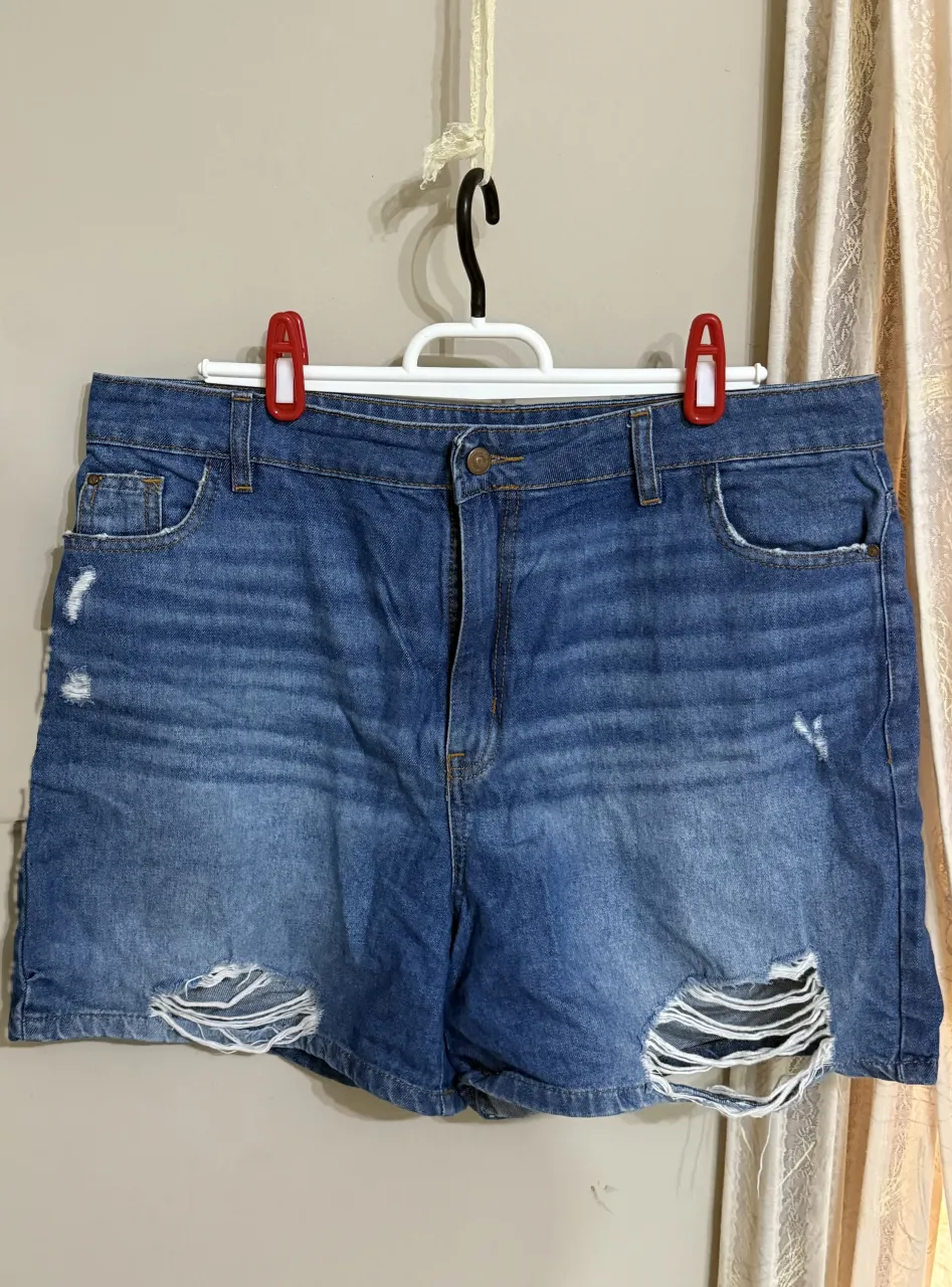 Short tiro alto de jean azules con roturas y desgastes. Tienen bolsillos delanteros y traseros. 32/42