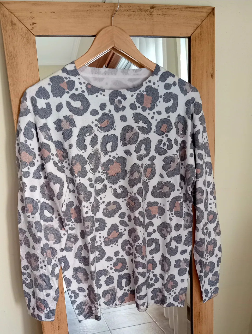 Sweater de manga larga con estampa de leopardo en blanco, gris y rosa.Mide 45 de hombro,56 de sisa y 67 de largo.