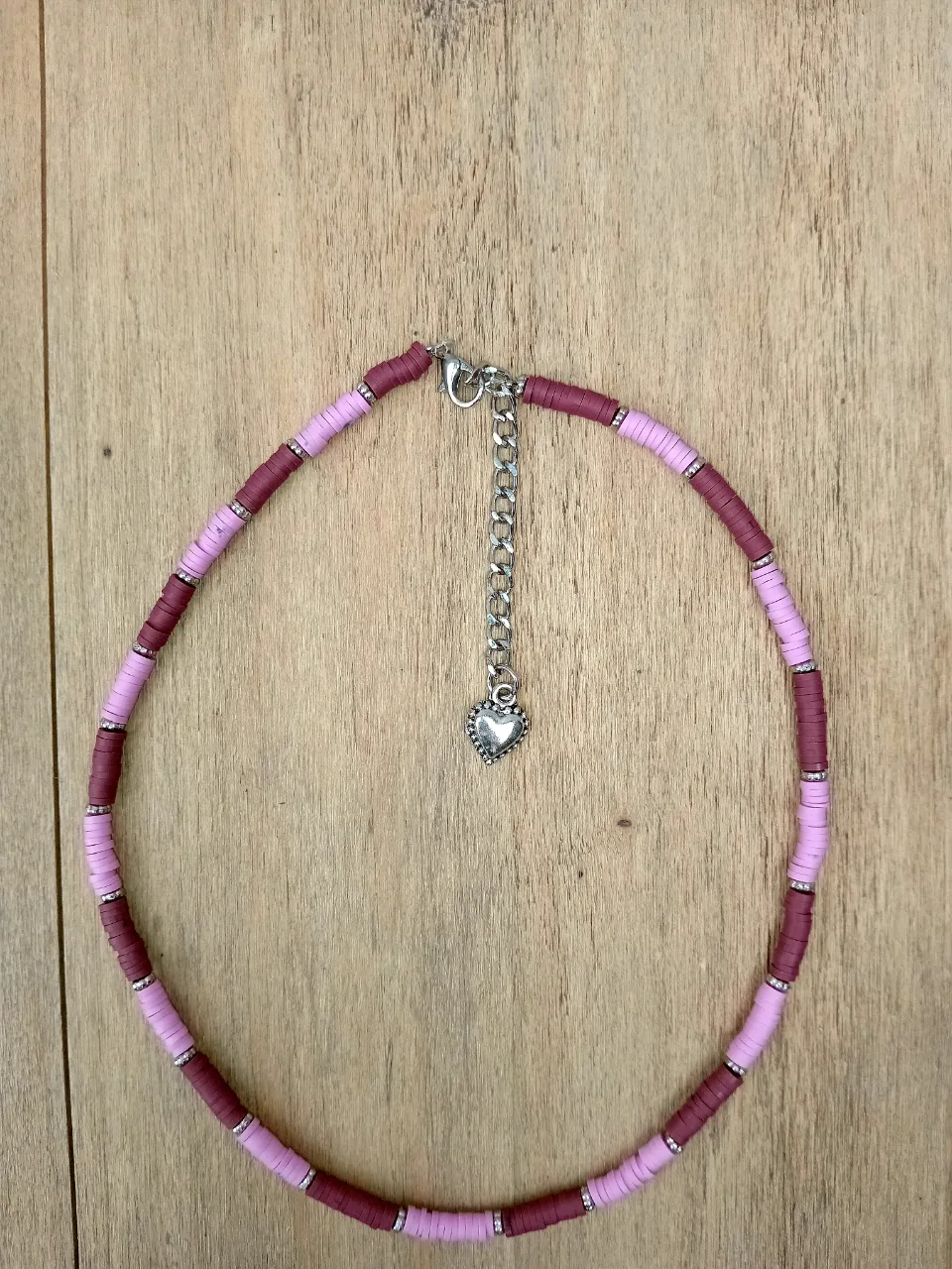 Collar choker de cuentas de colores, con dije de corazón plateado y cadena regulable. Ideal para darle un toque divertido y canchero a tu look.