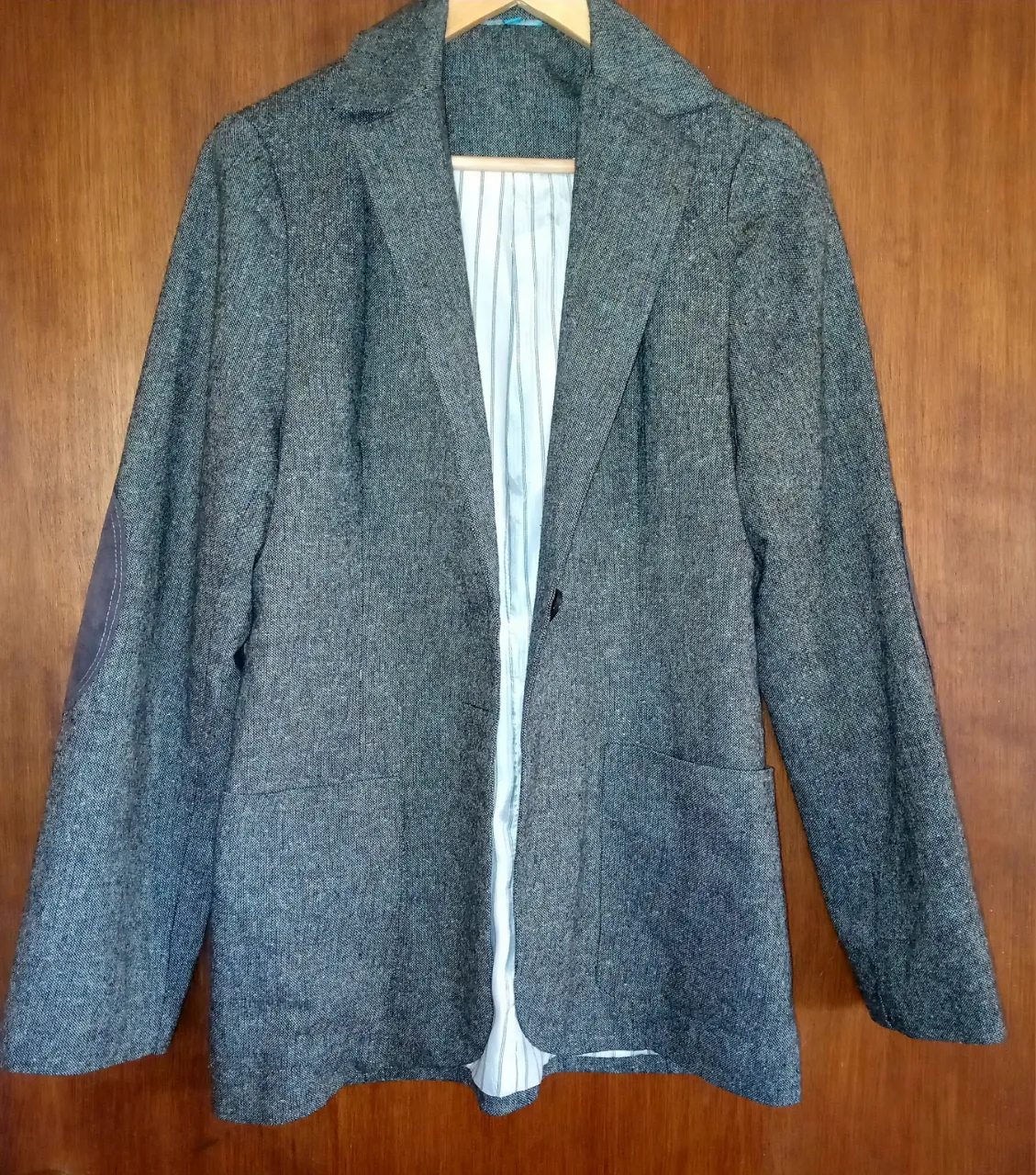 Blazer gris con forro a rayas blancas y negras. Posee parches de gamuza en los codos.Medidas de hombro 40,de sisa 51 ,de largo 74 cm.