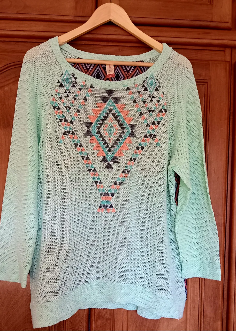 Sweater de tejido calado color verde menta con estampa geométrica en el frente y espalda. Mangas largas.