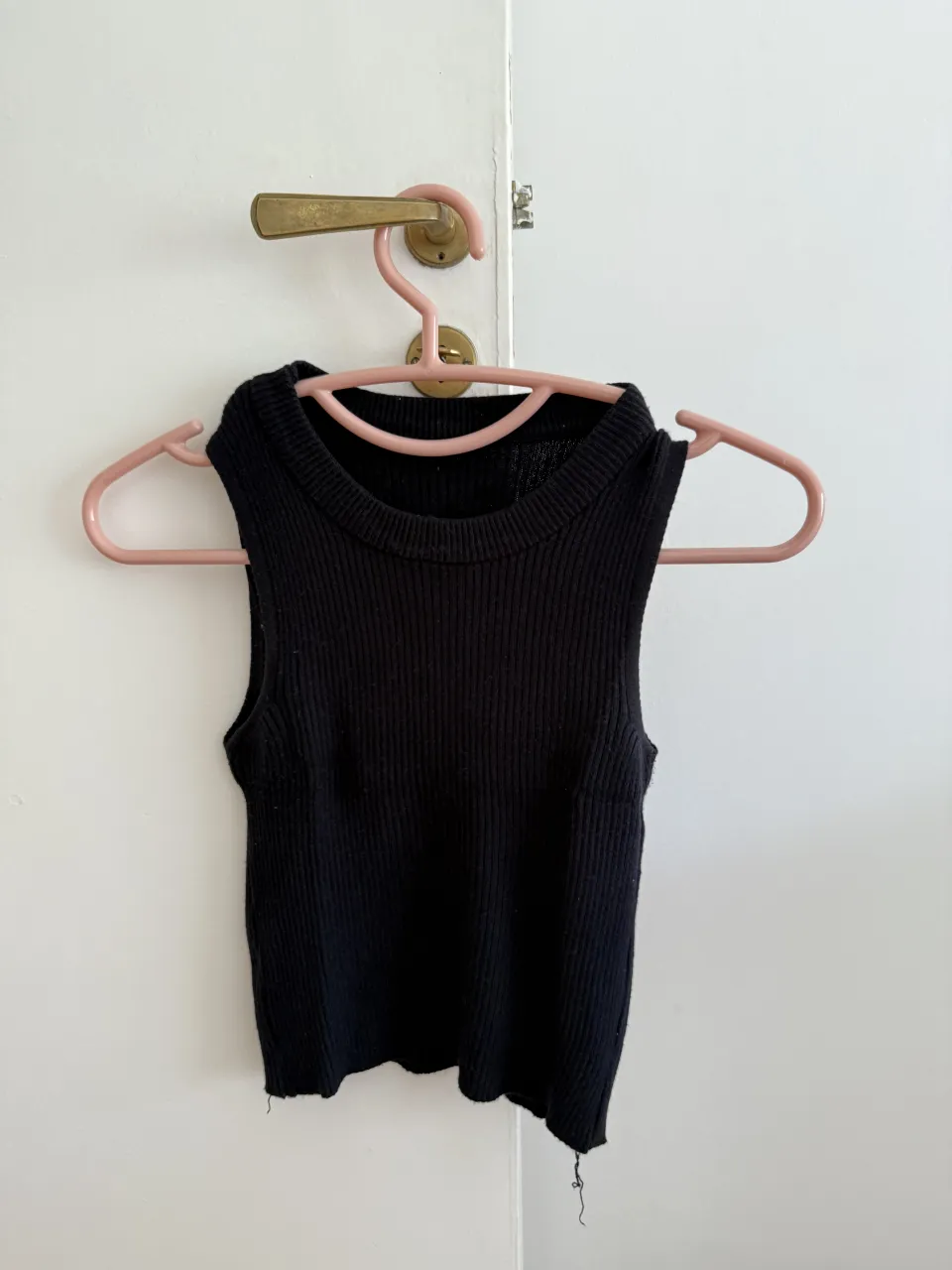 Musculosa negra de tejido acanalado. Tiene cuello redondo y breteles anchos.