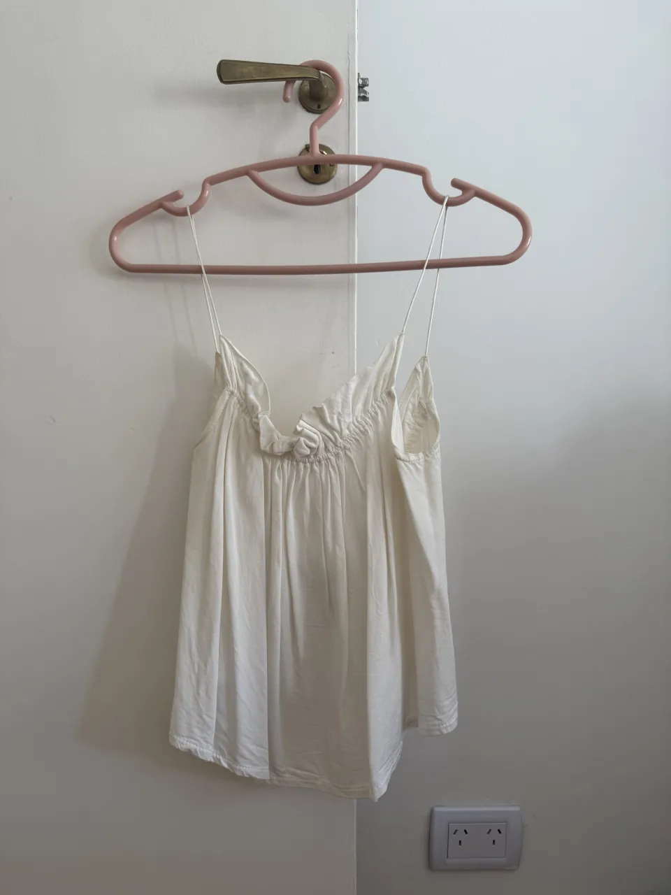 Musculosa blanca con tiras finas y detalle de fruncido en el escote. Posee un corte suelto. ‼️ Las imágenes de la modelo son a modo de referencia, la remera es la misma pero la que se vende no tiene textura. 