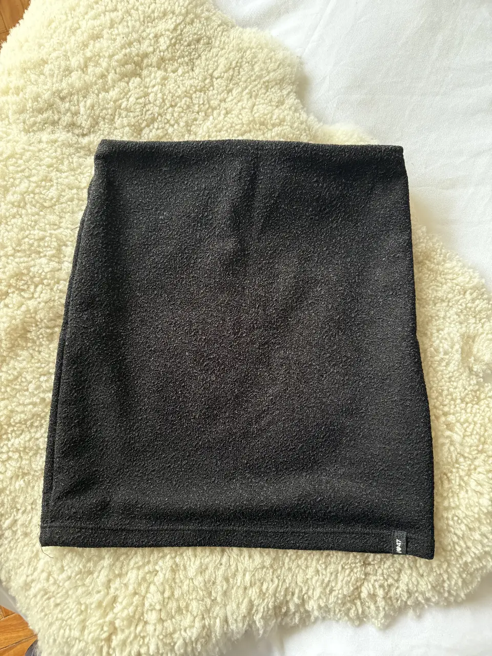 Mini falda apretada negra, ideal para salir de fiesta. Confeccionada en un tejido texturizado y pequeños brillos, ofrece comodidad y estilo. También se puede usar como bandeau. Medidas aproximadas: cintura 30cm y largo 37 cm. Es elastizada