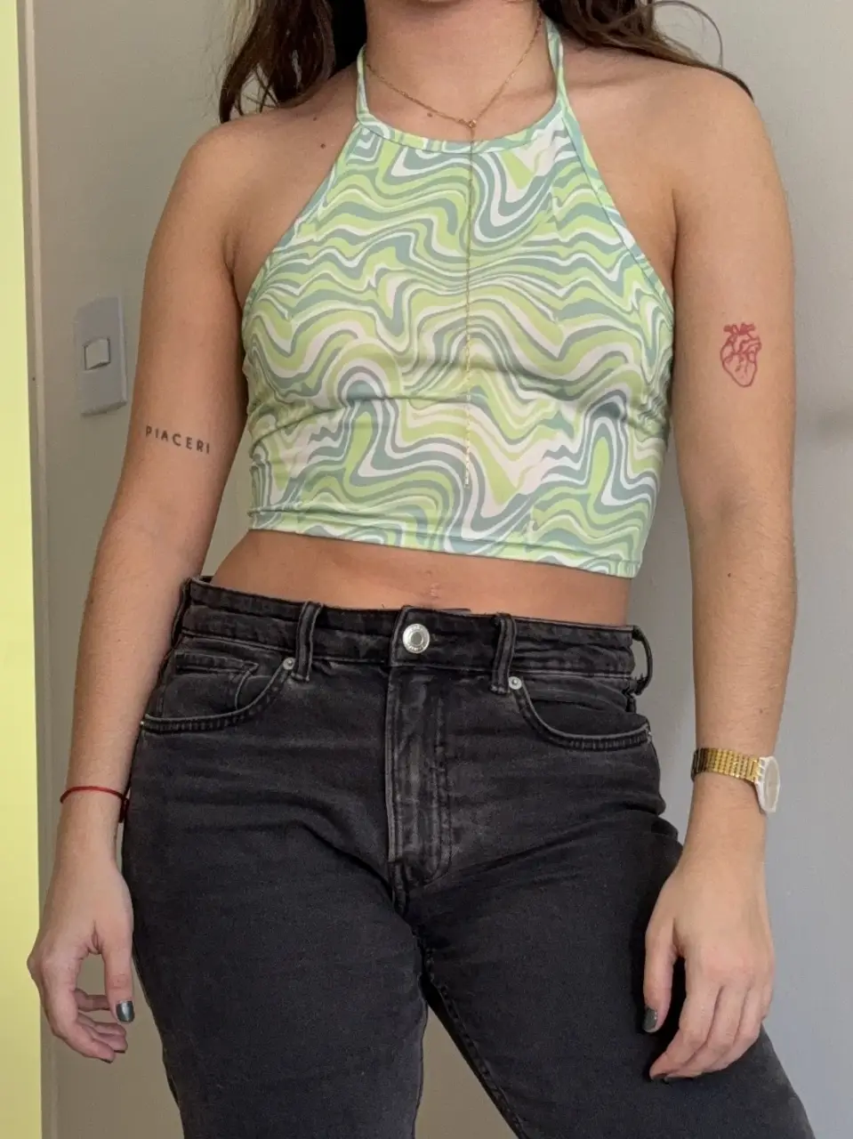 Top halter con estampado psicodélico en tonos verdes y blancos. Ideal para un look Y2K o festivalero. Combinalo con jeans tiro alto para un outfit canchero.