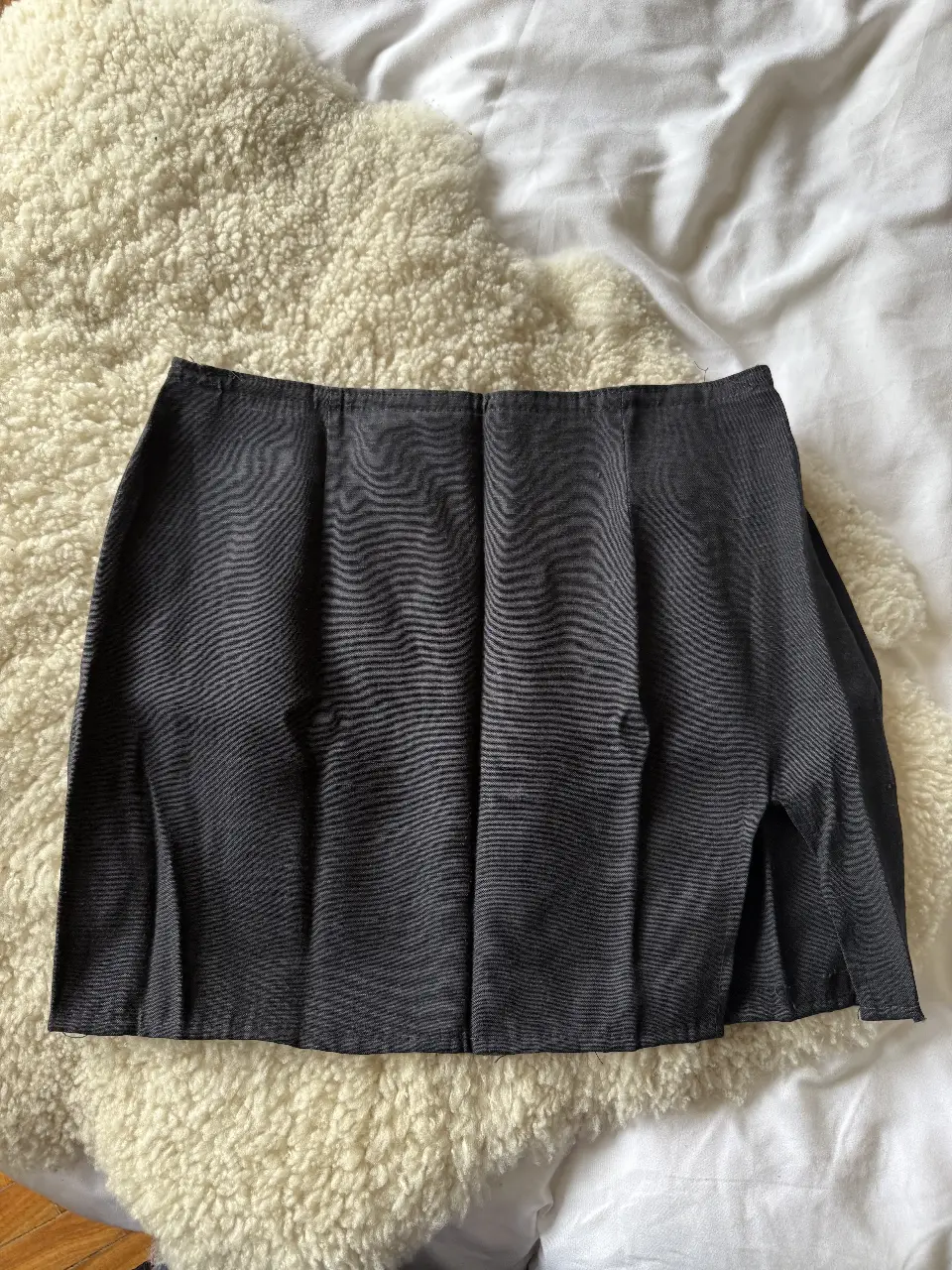 Pollera vintage sastrera gris oscura, con corte recto y abertura lateral. Ideal para un look elegante y versátil. Medidas aproximadas: cintura 35 cm, cadera 40cm y largo 35 cm. 