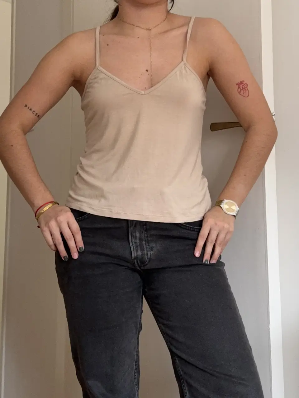 Top de tirantes finos en color crudo, ideal para combinar con jeans o pantalones de tiro alto. Perfecto para un look casual y fresco.