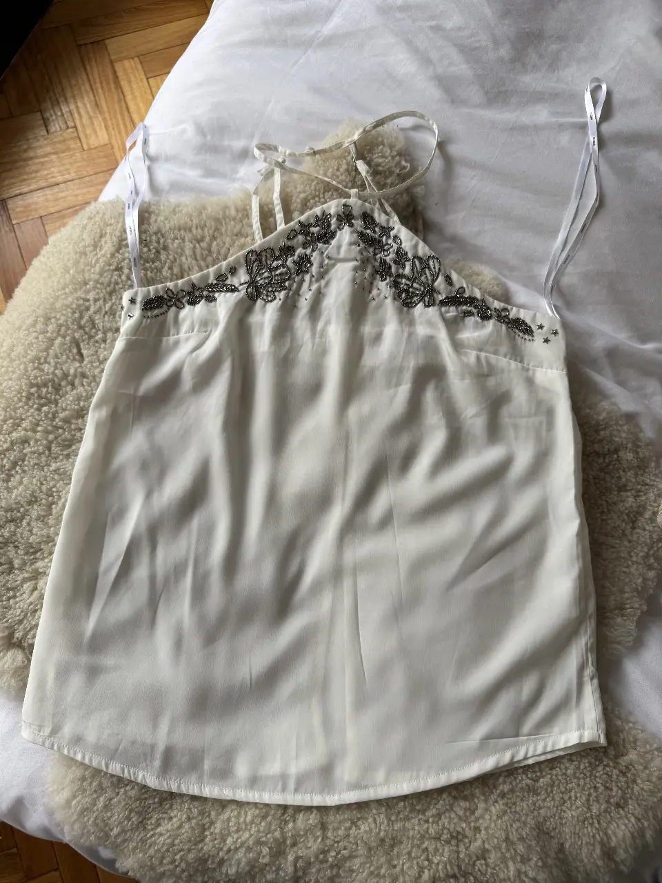 Top blanco con detalles bordados en la parte superior. Ideal para una ocasión especial o para darle un toque elegante a tu look.
