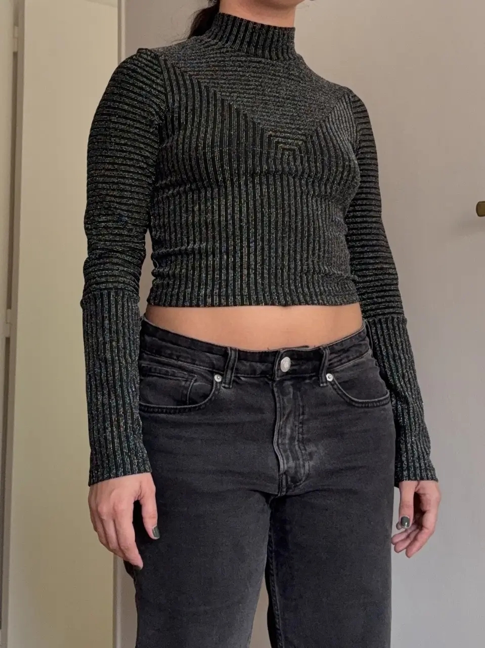 Top manga larga de cuello alto, con diseño de rayas verticales en color gris y negro. Ideal para un look moderno y sofisticado.