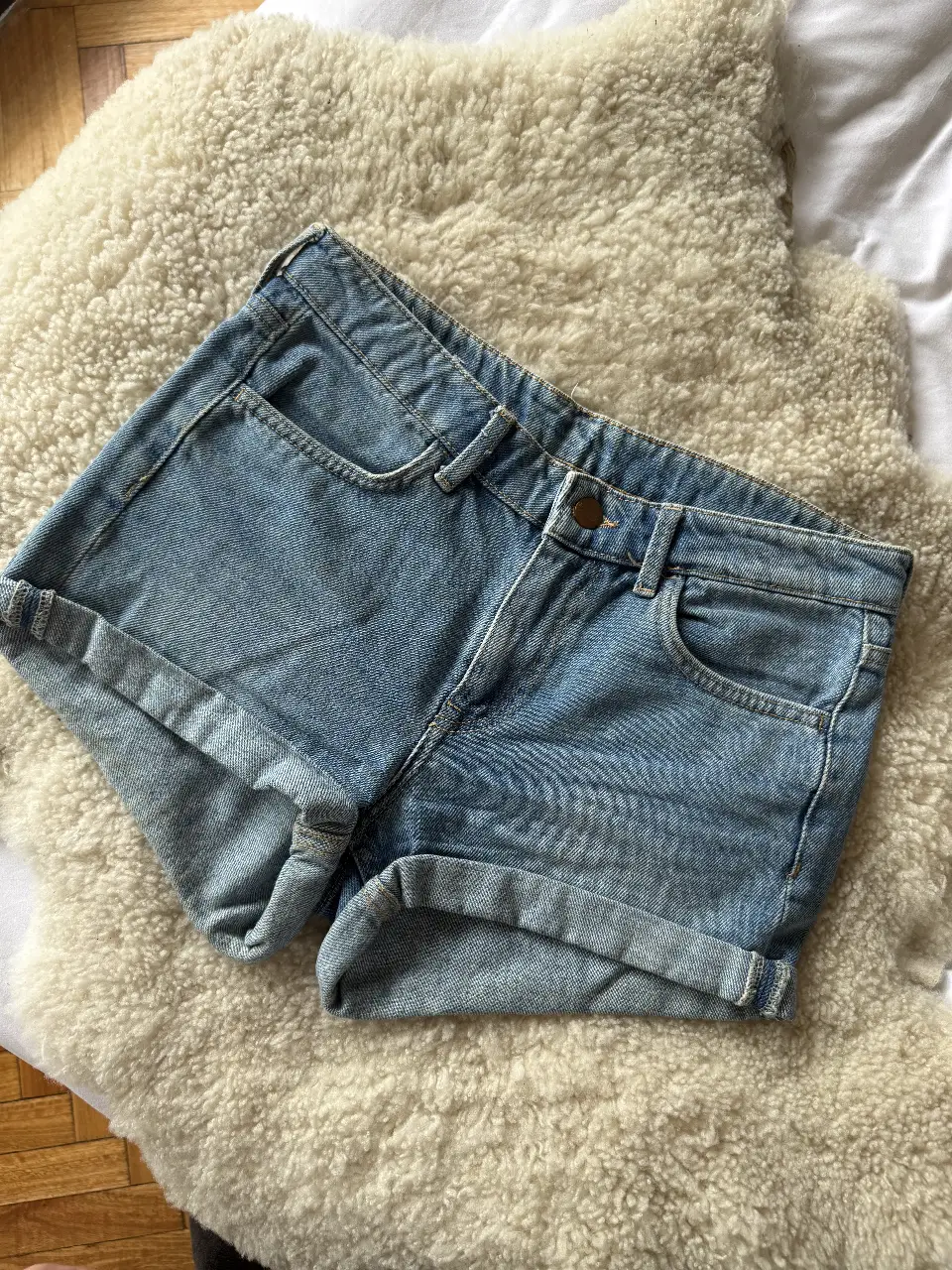 Short de jean de mujer, tiro medio, con bolsillos delanteros y traseros. Ideal para un look casual y cómodo.
