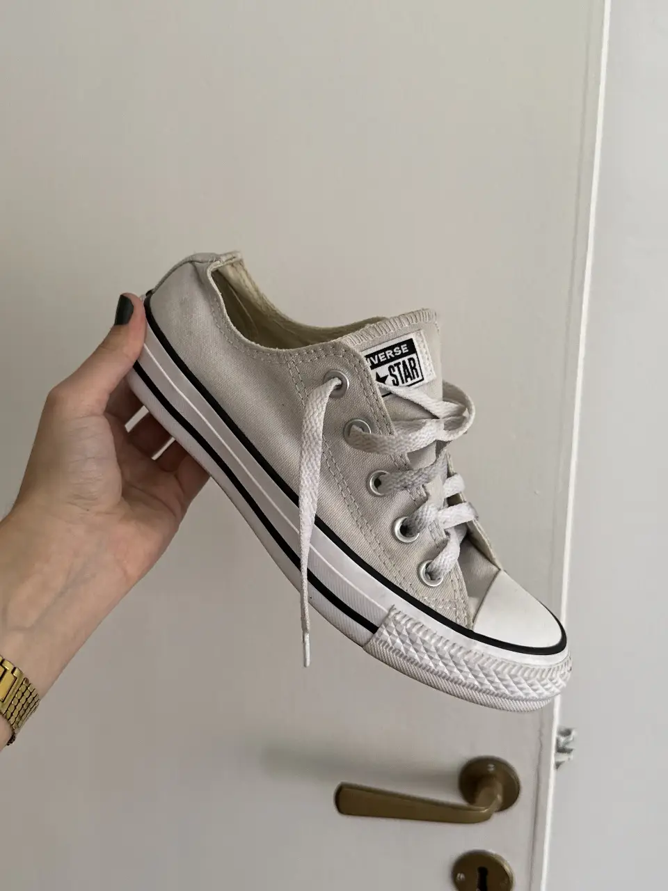Zapatillas Converse All Star bajas en color gris claro. Clásicas zapatillas de lona con puntera y suela de goma blanca. Ideales para un look casual y cómodo.