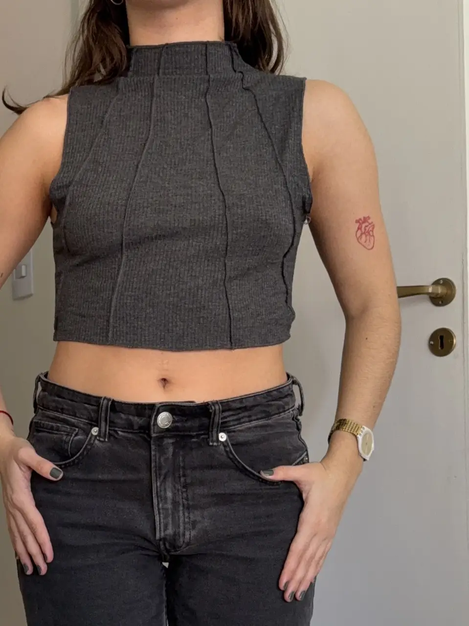 Top gris de cuello alto y corte crop, con costuras verticales que estilizan la figura. Ideal para un look moderno y versátil.