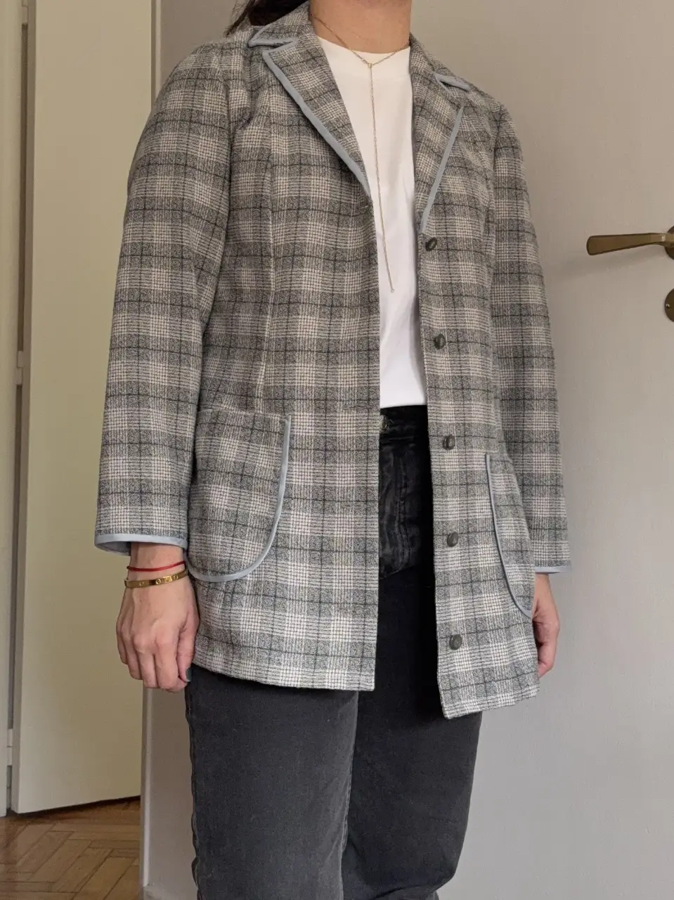 Elegante blazer de mujer con diseño a cuadros en tonos grises y detalles celestes. Ideal para un look preppy y sofisticado. Perfecto para el trabajo o salidas casuales.