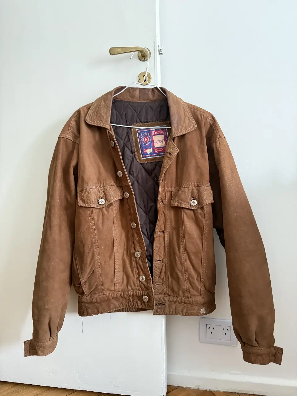 Campera de cuero marrón con cuello solapa y dos bolsillos delanteros. Estilo vintage con etiqueta "by ameil factory clothing high quality". Ideal para un look casual y canchero. 100% cuero natural.  en la espalda tiene un logo de harley davidson